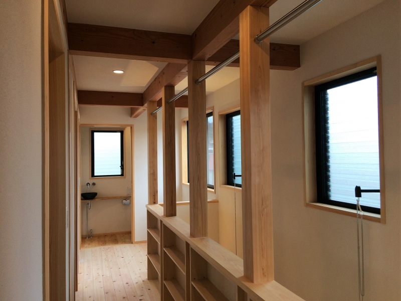 洗濯物が部屋干しできるパイプを取り付けた２階階段手すり兼本棚収納