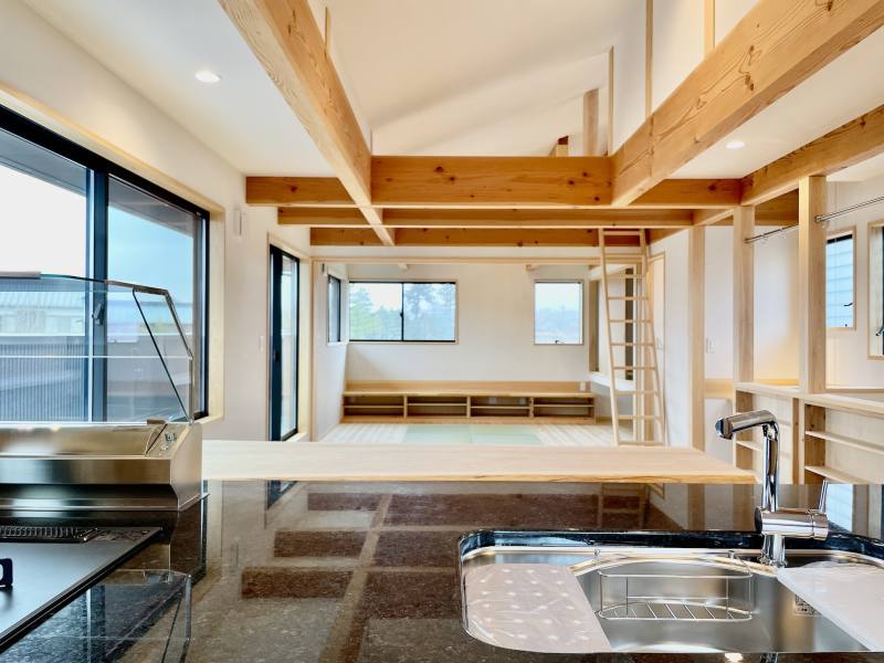 ルーフバルコニーと階段に隣接した吹抜けのリビング